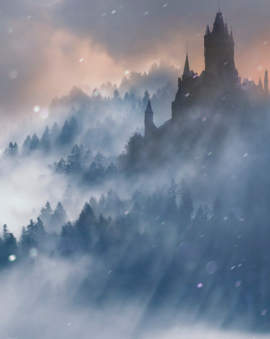 A castle on a forested mountain with thick cloud mingling with the trees.